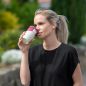 Preview: Eine junge Frau trinkt aus einem Waycup-Becher
